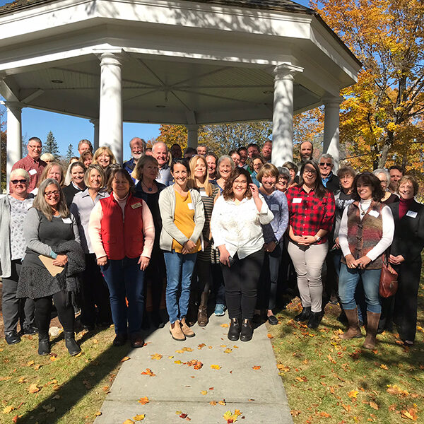 a group of people in front of a gazebo in the fall
