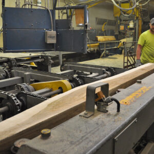 Three men standing with a milling log