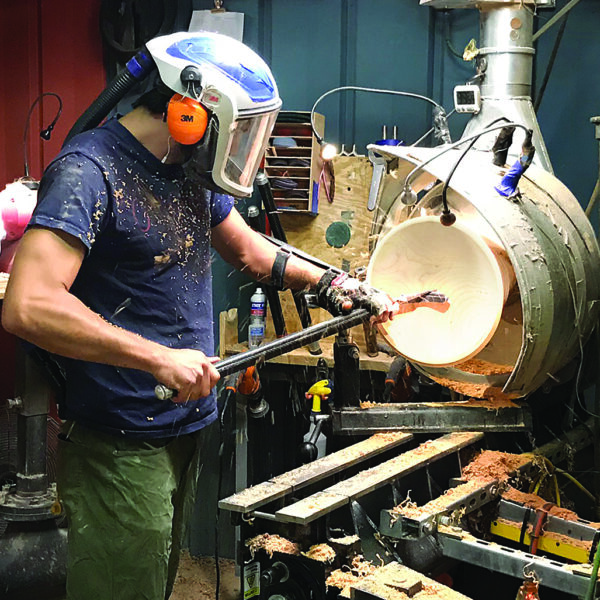 Employee turns a wooden bowl on the lathe at Andrew Pearce Bowls