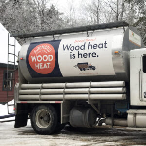 A truck delivers wood pellets to a home for heat through automated delivery.