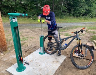 A bicyclist uses the new repair station to inflate a flat tire in Gorham, NH.