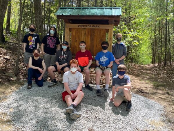 Boy Scouts gather around trailhead kiosk they assembled.