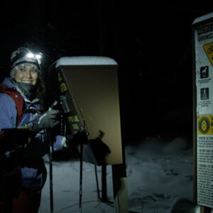 woman x-c skiing at night in Tupper Lake, NY