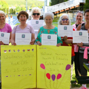 Women over 50 display certificates for wellness walk.