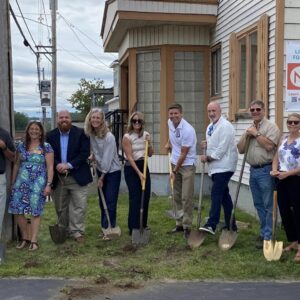 People with shovels in front of building