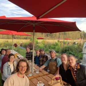 Young adults socialize at a picnic farm supper in the Adiriondacks.
