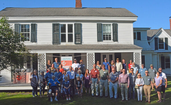 People gather in front of the historic Hale House in Elizabethtown, NY, to celebrate the beginning of its redevelopment.