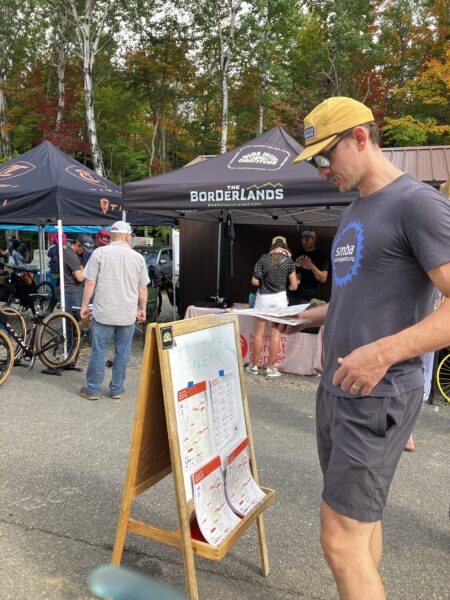 Man looks at mountain biking map at an event.