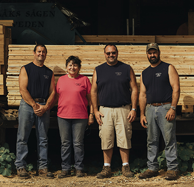 Four members of the Goodridge family pose at their sawmill in Albany, Vermont