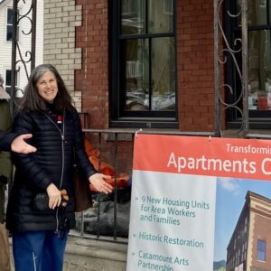 Three people standing in front of a building undergoing renovation.