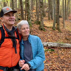 Man and woman standing in the forest in the fall.