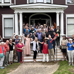 a crowd of people celebrates the opening of new apartments in an historic building.