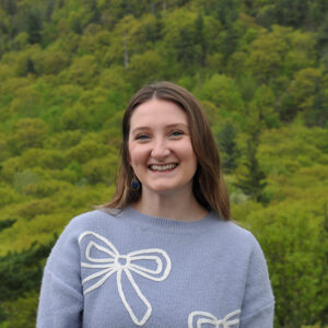 woman smiling in front of trees