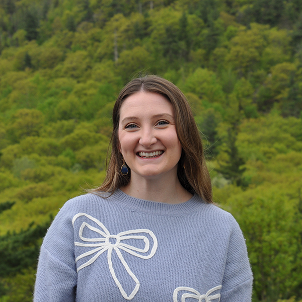 woman smiling in front of trees