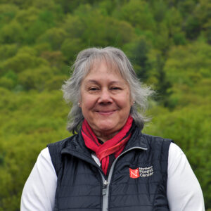 woman smiling in front of trees