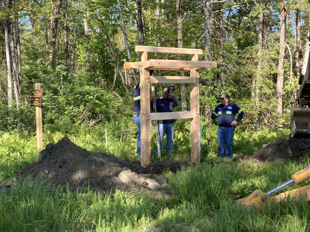 Trail crews build a kiosk for a new trail sign