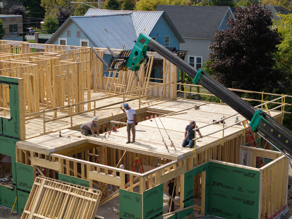 Crews install cross-laminated timber floor assemblies in new apartment building.