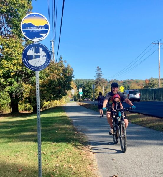 Man and boy ride bike along new Memphremagog Greenway in Vermont.