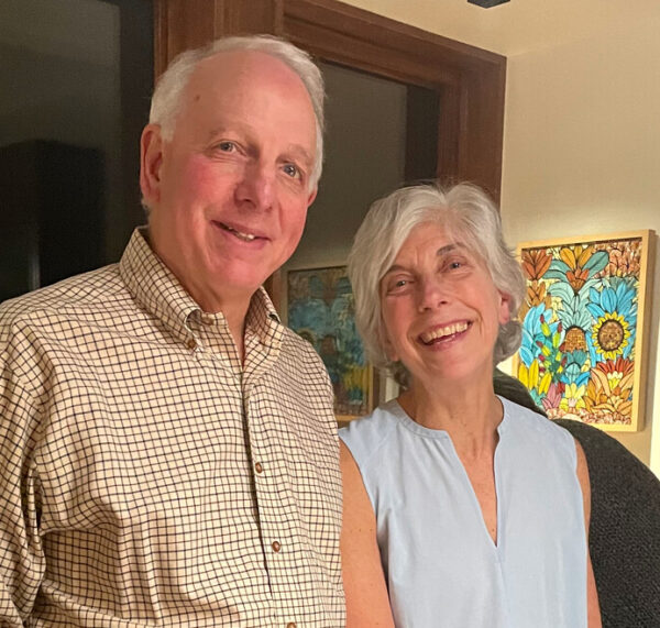 A man and woman smile at the camera.